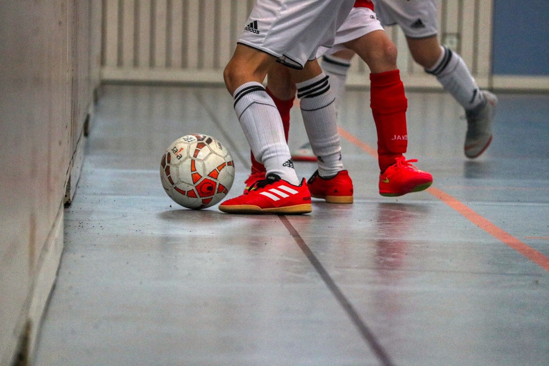 Fußball 4 Sportlerbeine mit einem Fußball