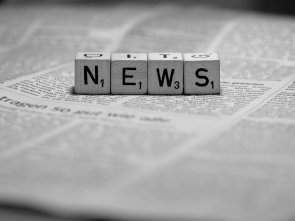 News Würfel mit den Buchstaben N, E, W und S auf einer Zeitung liegend
