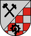 Schild schräglinks geteilt, rechts in Silber schräggekreuzt ein schwarzer Hammer und ein schwarzer Schlägel, links rot-silber geschacht, belegt mit einer schwarzen Abtskrümme.