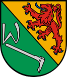 Schild schrägrechts geteilt, rechts in Grün ein silbernes W und eine silberne Rodehacke, links in Gold ein blaubewehrter und -gezungter roter Löwe.