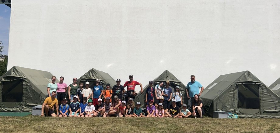 Jugendpflege – Angebote, Beteiligung und Unterstützung für junge Menschen Jugendpflege - Outdoorcamp - Kinder mit Betreuer*innen vor den Outdoorzelten